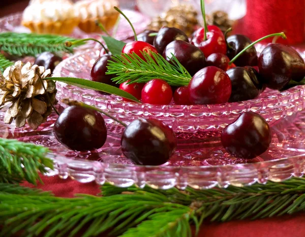 Christmas dessert - cakes with red berries cherries,  cranberries and christmas tweeg