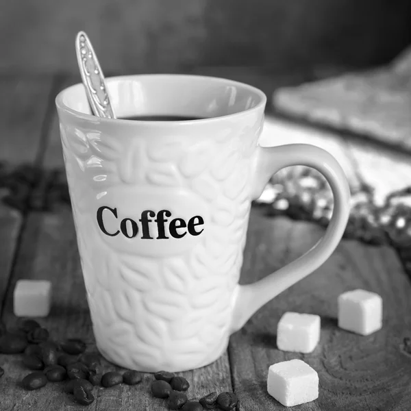Mug of coffee on the old boards, black-and-white image