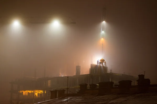 Construction site at night in the fog