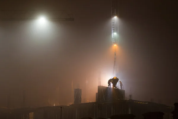 Construction site at night in the fog