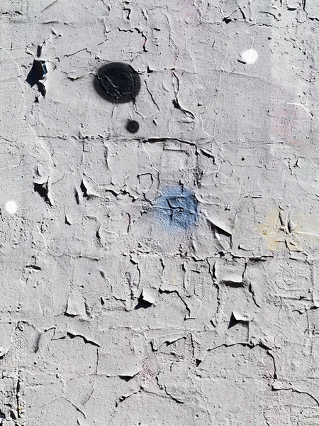 Detail of graffiti on the wall of the old building. Grungy concrete surface with cracks, scratches and streaks of paint.