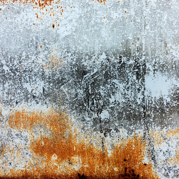 Abstract rusty metal surface with cracked white paint. Textured