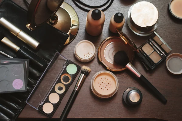 Set of decorative cosmetics . Eye shadows, bronzer, concealer,colour correctors. Wooden background.