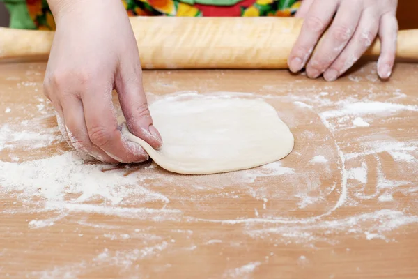 Female hand holding a circle of dough