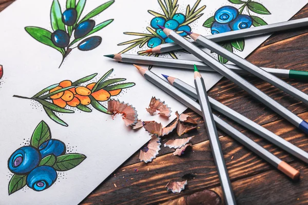 Beautiful sketch drawing with colored pencils lying on old wooden background