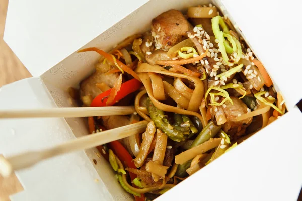 Chinese noodles with vegetables and shredded duck in take away containers.
