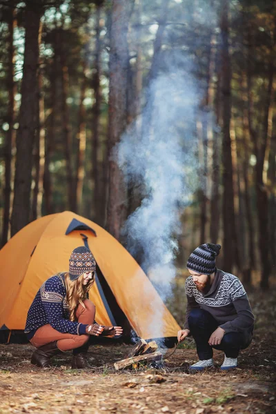 Couple of hikers sitting near the fire