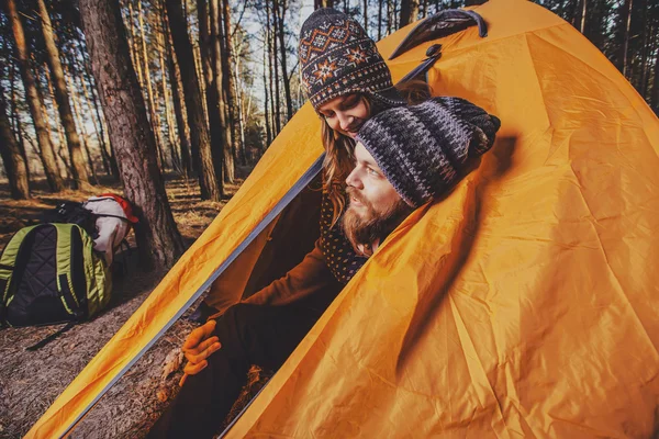 Couple of hikers setting a tent in the wood