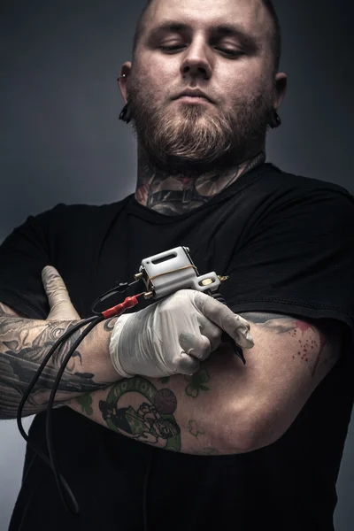 Man tattoo artist with tattoo machine
