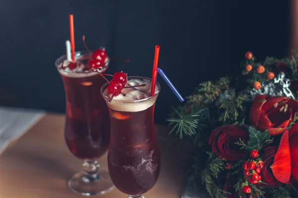 Beautiful red cocktail with cherries and wedding rings,a wedding bouquet of red roses