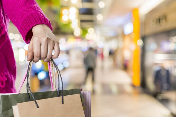 Exciting young shopping woman hold bags, closeup portrait with copyspace.