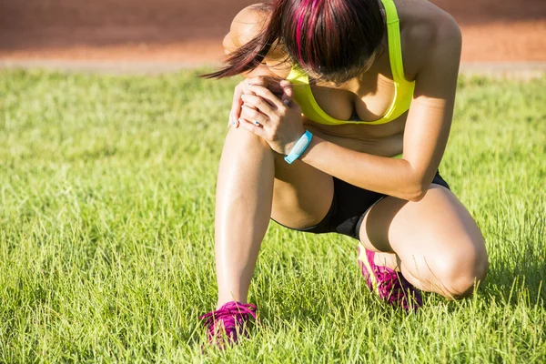 Running sport injury - twisted broken ankle. Female athlete runner touching foot in pain due to sprained ankle.