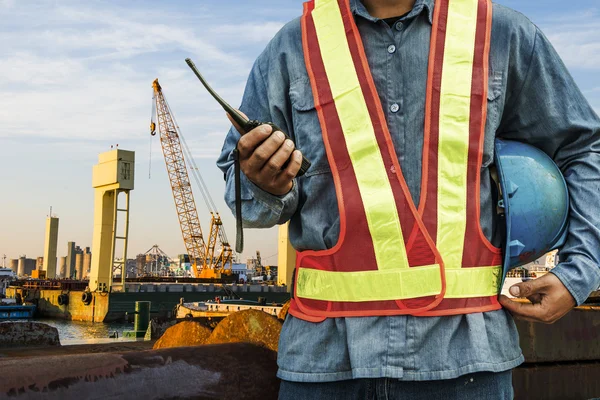 Worker with large crane site and sunset background