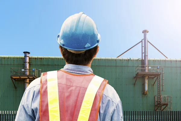 Construction worker checking location site with crane on the background