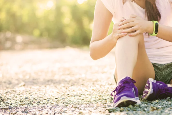 Runner sport knee injury. Woman in pain while running in park