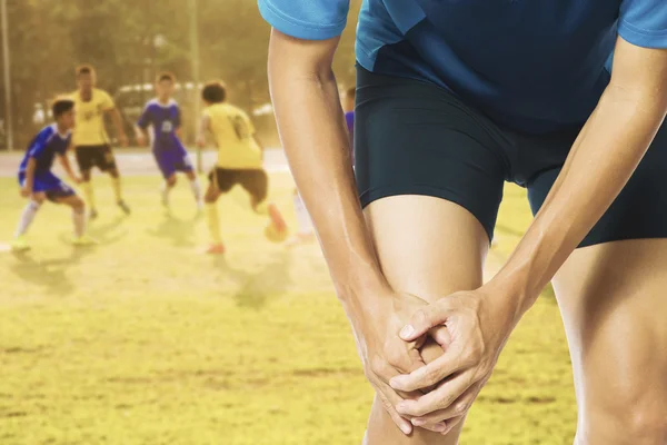 Male athlete runner touching foot in pain due to sprained ankle