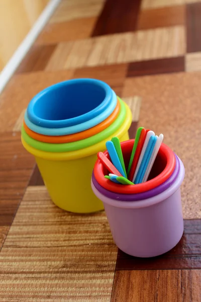 Colorful plastic sticks in plastic cups