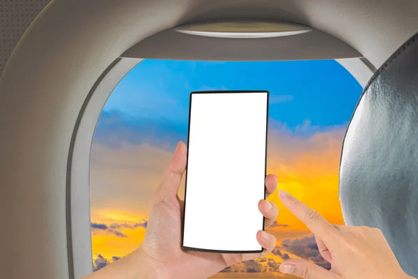 Male hand is holding a modern touch screen phone and image of seat on airplane