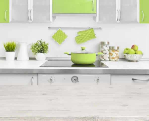 Wooden table on green modern kitchen bench interior background