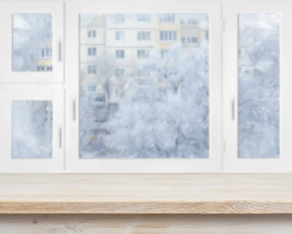 Wooden table surface over frosty window background