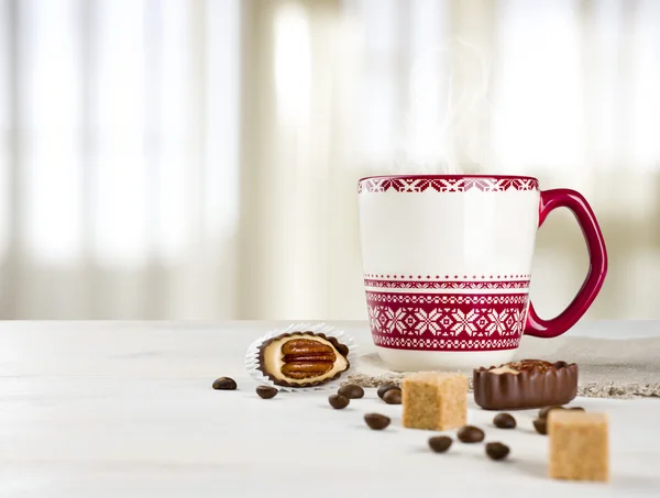 Hot coffee cup on table over blurred curtained window background