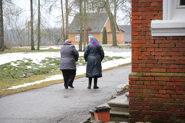 Rear view of two walking old women