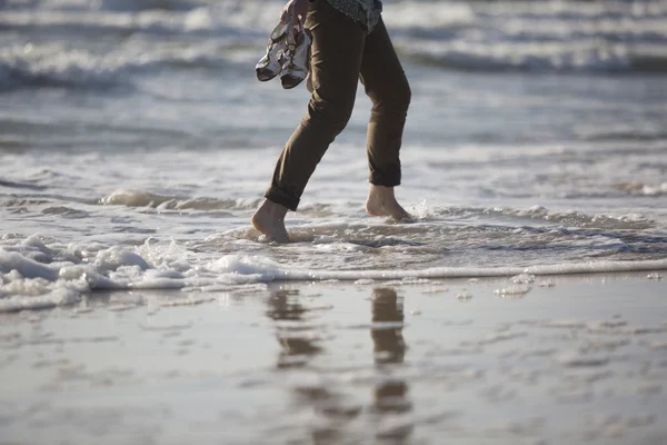 Woman\'s legs walking by sea shore