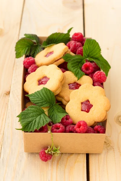 Homemade cookies with raspberry jam and fresh raspberries