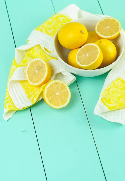 Fresh lemons in a white bowl on wooden background.Half of lemon.The view from the top.