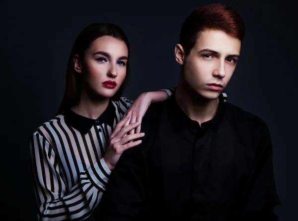 High fashion portrait of young elegant couple over black backgro