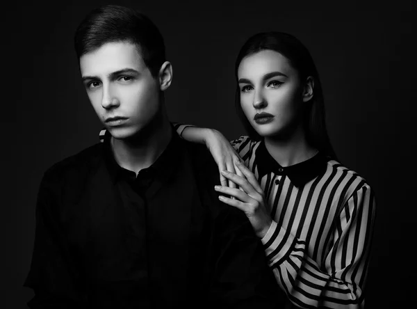 High fashion portrait of young elegant couple over black backgro