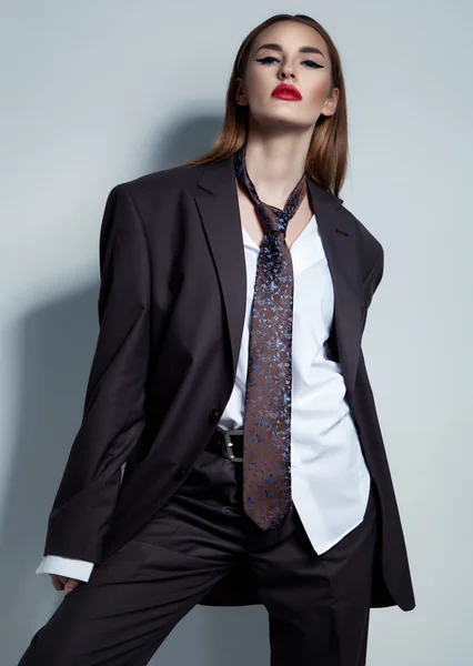 Business style concept. Young woman in male suit and tie.