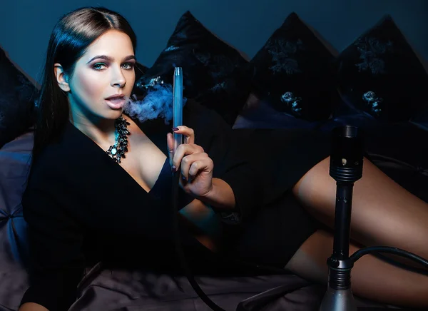 Beautiful and sexy glamourous woman smoking hookah