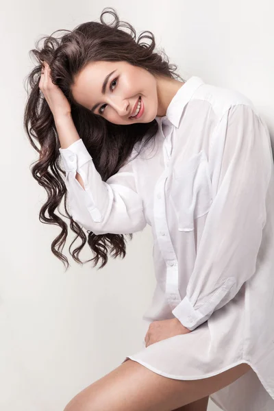 Young and pretty young woman in white shirt smiling and looking