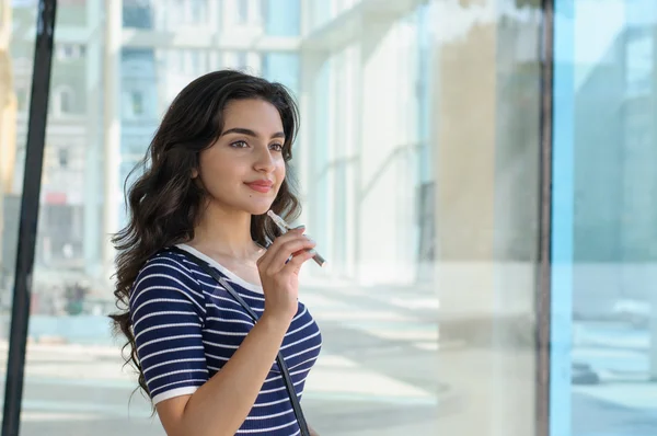 Woman smokes electronic cigarette.