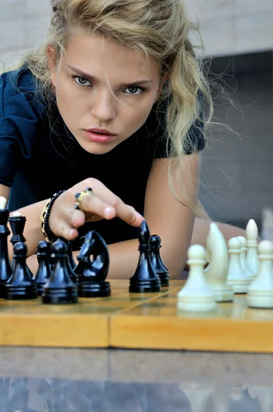 Woman makes a move chess elephant.