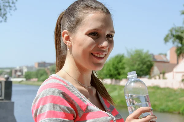 Sport woman drinking water and smiling