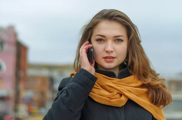 Girl in orange scarf talking on phone