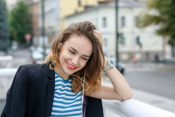 Girl listening to music on headphones and laughs