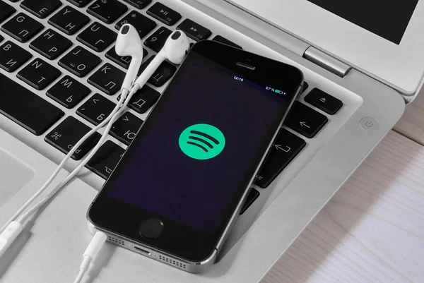 IPhone 5s on laptop with mobile application for Spotify on the s