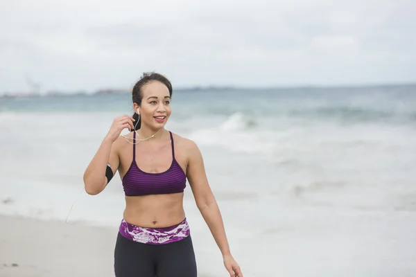 Fitness Woman finishing work out by the Ocean at cloudy winter day