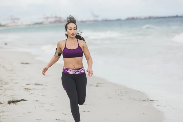 Fitness Woman finishing work out by the Ocean at cloudy winter day