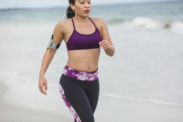 Fitness Woman finishing work out by the Ocean at cloudy winter day