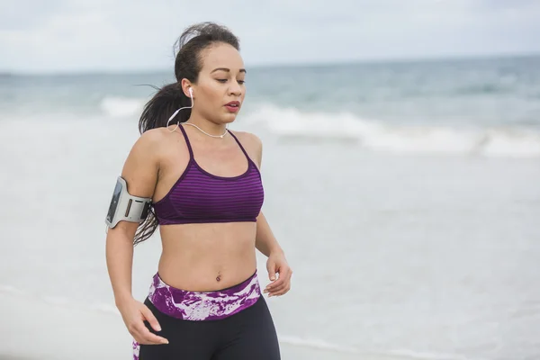 Fitness Woman finishing work out by the Ocean at cloudy winter day