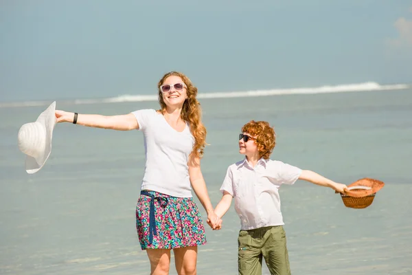 Mother and son having family time on holidays walking along the beach. Travel, holiday, vacation concept