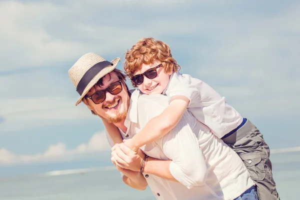 Hipster father with beard and red haired son having happy summer time at a sunny day. Concept of friendly family