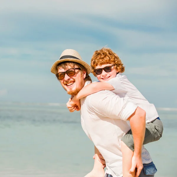 Hipster father with beard and red haired son having happy summer time at a sunny day. Concept of friendly family