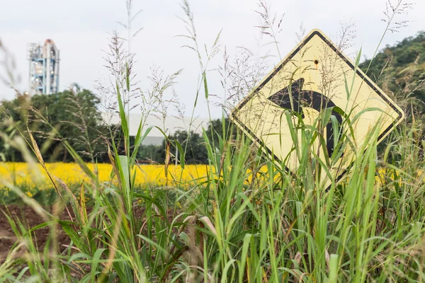 Grass overlay traffic Signs turn left and factory background