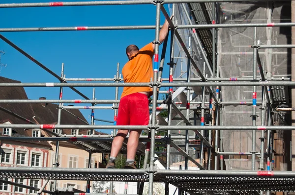Worker on scafold on renovation site