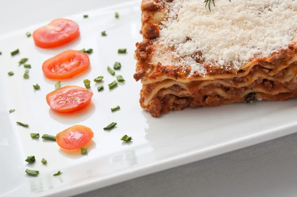 Lasagna with cherry tomatoes presentation in a plate